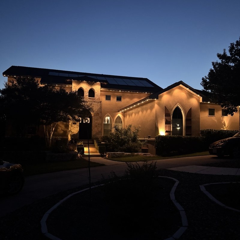 A Texas home glowing with warm white permanent LED roofline lighting at twilight