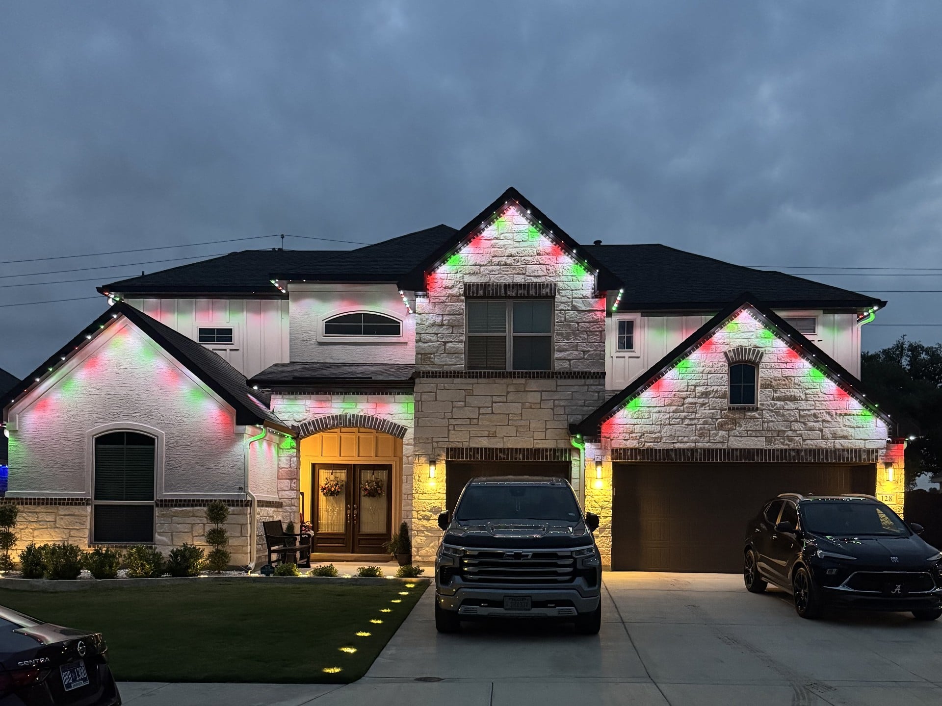 Same Texas home with red and green Christmas permanent LED roofline lighting