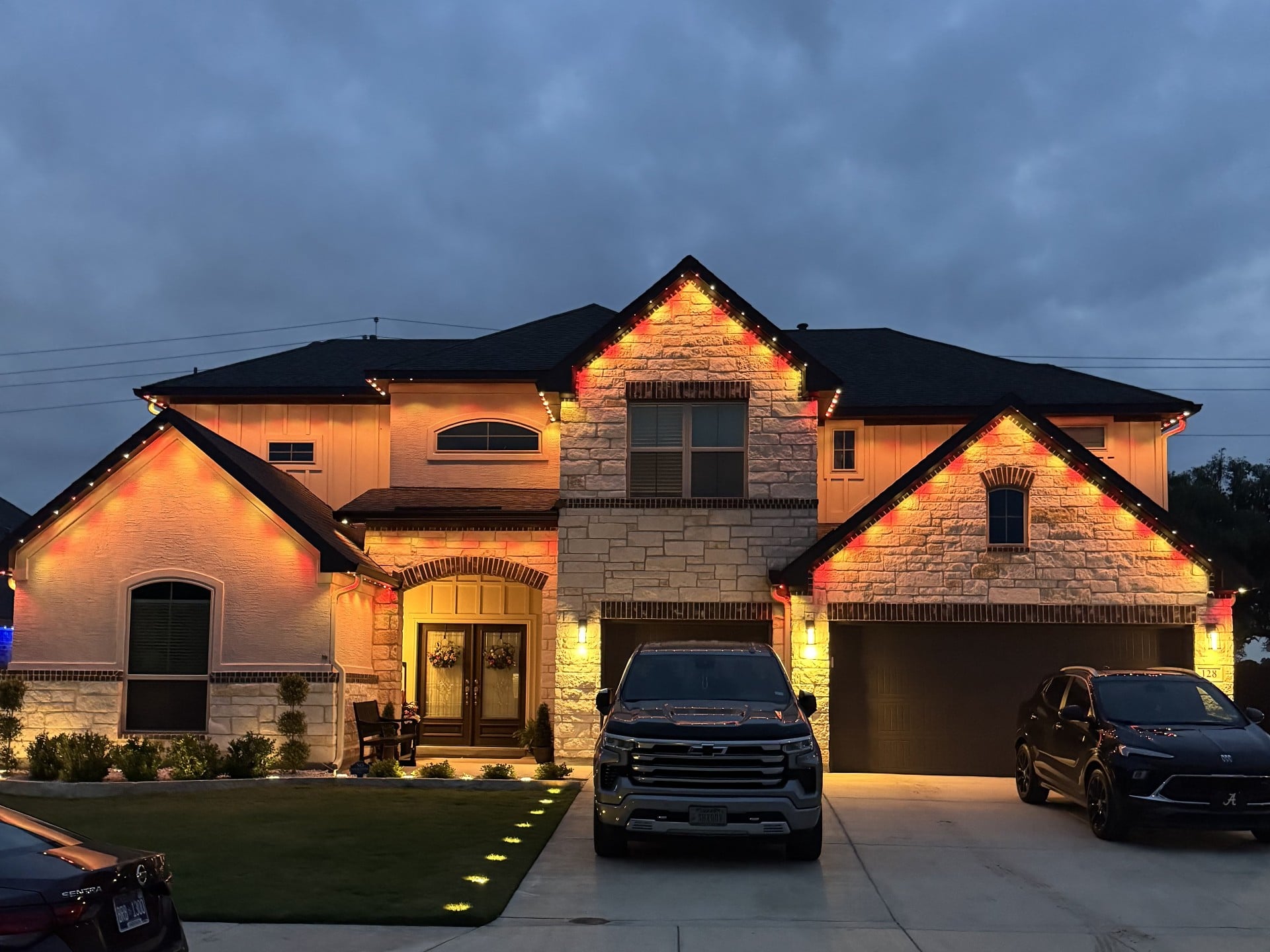 Same Texas home with orange and red Halloween permanent LED roofline lighting