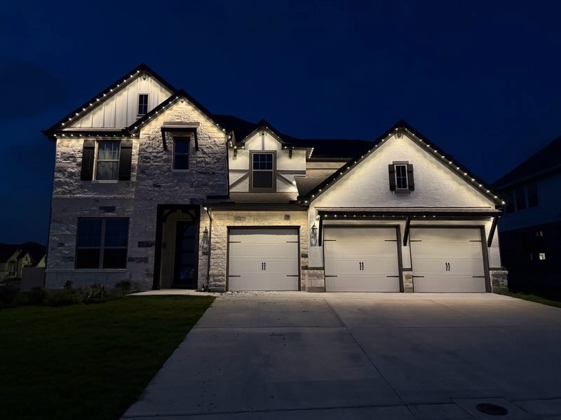 Texas Hill Country home with warm white permanent LED roofline lighting at dusk