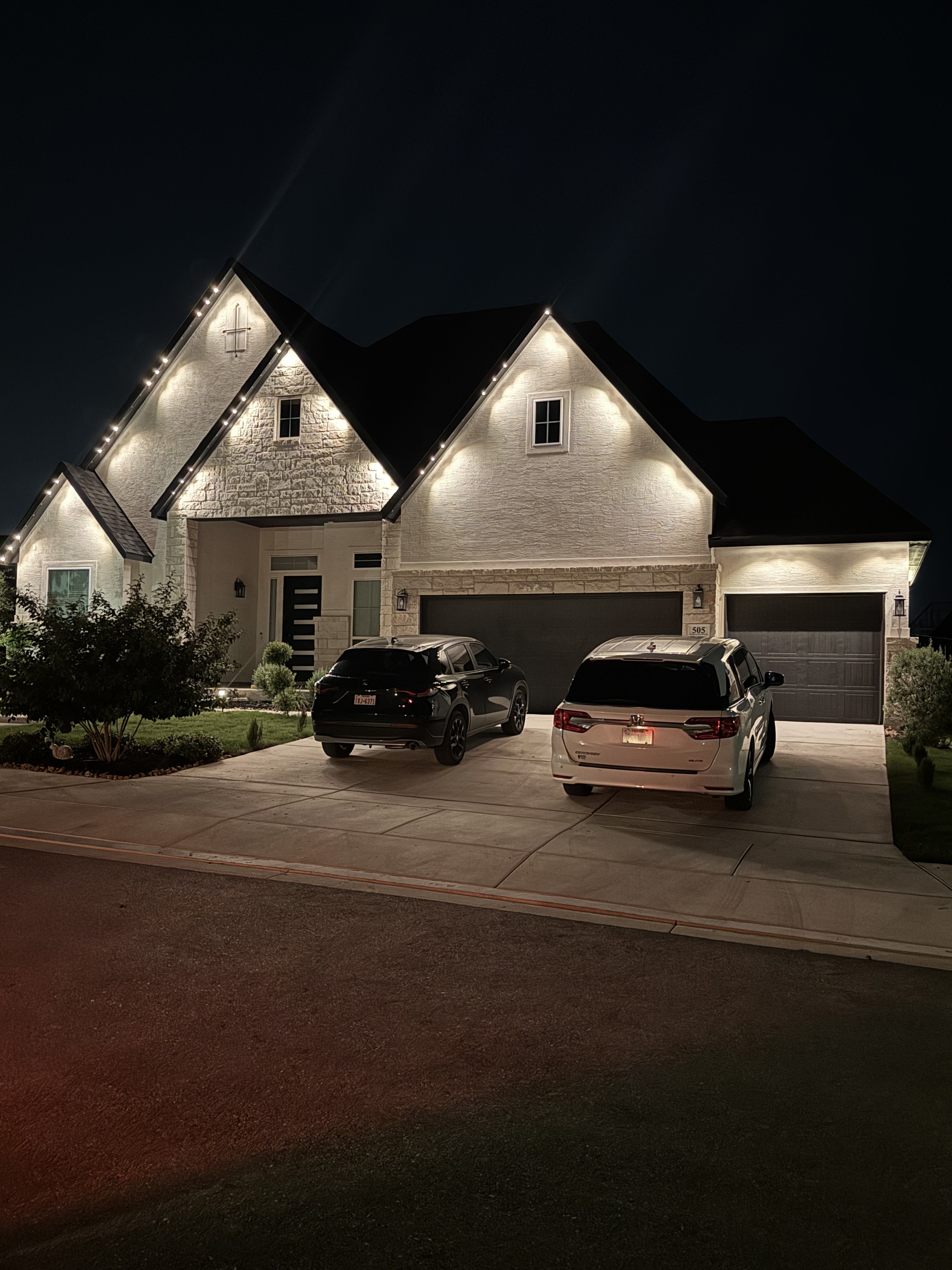 Texas single-story home with warm white permanent LED roofline lighting at night